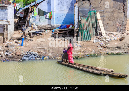 Local woman in colourful sari on a makeshift wooden ferry in slums on the ocean shore in Chennai, Tamil Nadu, southern India Stock Photo