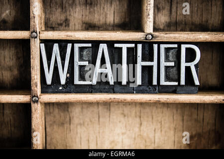 The word 'WEATHER' written in vintage metal letterpress type in a wooden drawer with dividers. Stock Photo