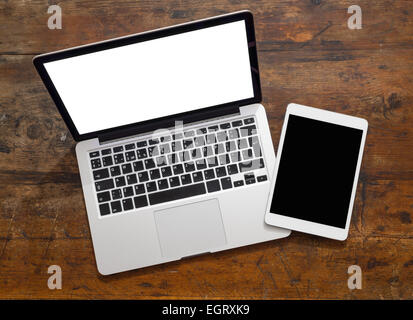 Open laptop with digital tablet, with isolated screen on old wooden desk Stock Photo