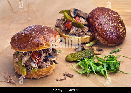 Two sandwiches with pulled pork, pickles and grilled mushrooms  in home made brioche buns. Stock Photo