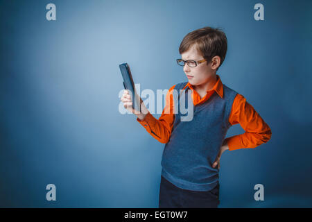 European-looking boy of  ten years in glasses  looks at the plat Stock Photo