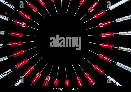 Used syringes arranged in a circle; concept shot for drug abuse Stock Photo