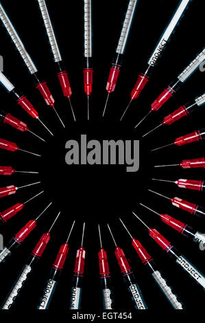 Used syringes arranged in a circle; concept shot for drug abuse Stock Photo