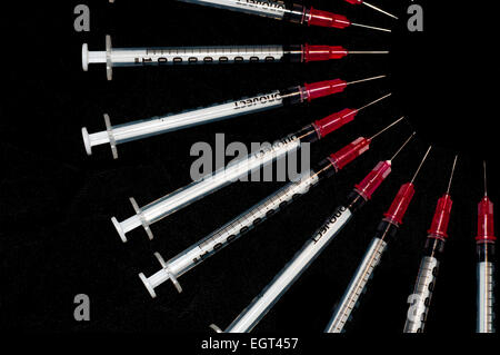 Used syringes arranged in an arc; concept shot for drug abuse Stock Photo