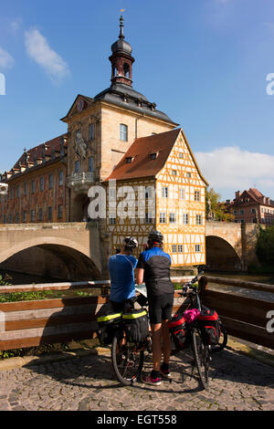 Cycling tourists check their map in front of Bamberg's Old Town Hall (Altes Rathaus), built in 1462. Stock Photo