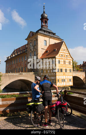Cycling tourists check their map in front of Bamberg's Old Town Hall (Altes Rathaus), built in 1462. Stock Photo