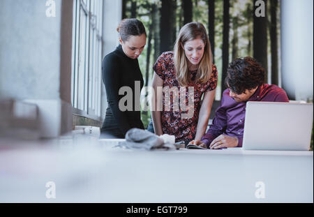 Young business team working together on a creative idea, Young people discussing new business project in office. Stock Photo