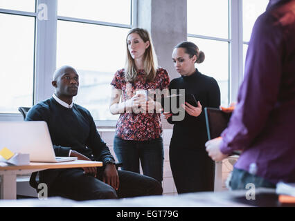 Business people having informal meeting in office. Diverse team of young people discussing work. Stock Photo