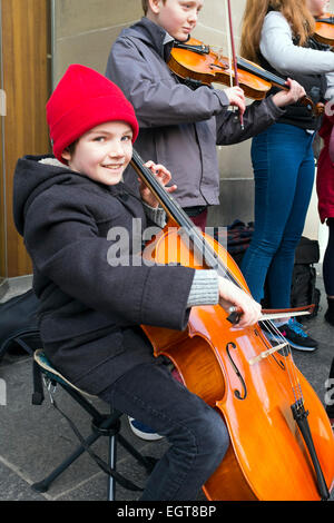 Donald McGregor, aged 9, from Glasgow busking in Sauchiehall Street Glasgow, playing with other children. Stock Photo