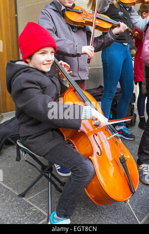 Donald McGregor, aged 9, from Glasgow busking in Sauchiehall Street Glasgow, playing with other children. Stock Photo