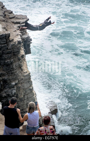 The Diving Monk at the El Salto del Fraile Restaurant in Lima Peru dives off a cliff as tourists watch Stock Photo