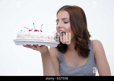 Portrait of a young woman bitting cake over gray background Stock Photo