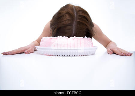 Woman lying on the table with face in cake Stock Photo