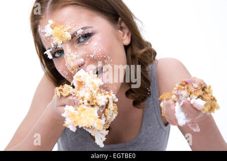 Young cute woman eating cake over white background Stock Photo