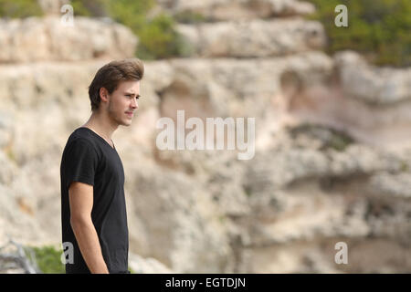 Portrait of a man exploring and looking away in the mountain with an unfocused background Stock Photo