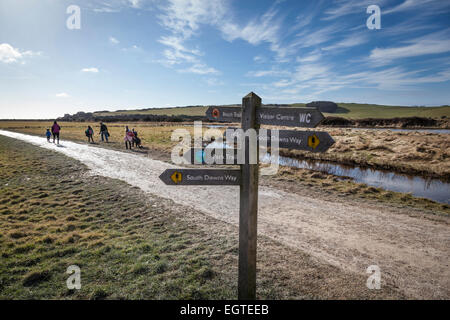 Day trippers make their way towards the beach at Cuckmere Haven on a sunny winter's day. Stock Photo