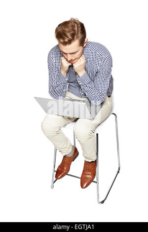 Young man thinking over the computer. He is sad. Stock Photo