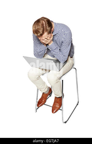 Young man is crying over the keyboard. Isolated on white background. Stock Photo