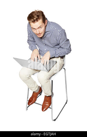 Young man leaning over the keyboard on his knees. Stock Photo