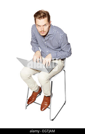 Young man leaning over the keyboard. Facial Expression. Stock Photo