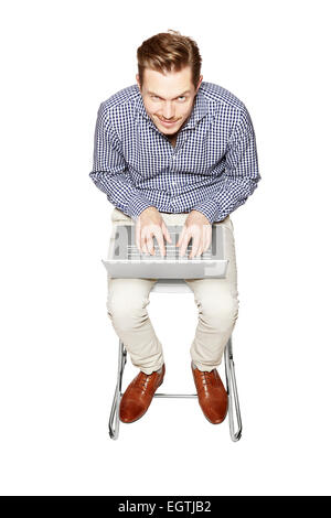 Young man working on a computer on his knees. Stock Photo