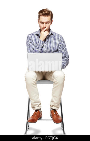 Young man working on a computer and thinking. Stock Photo