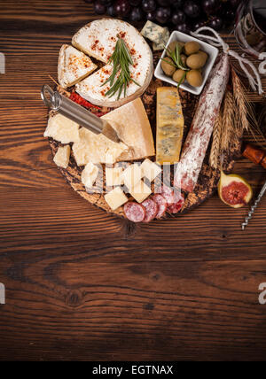 Cheese arrangement served on cutting board. Shot from aerial view Stock Photo