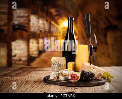 Various kind of cheese with red wine in cellar Stock Photo