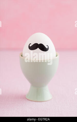 Easter egg with moustache in egg cup Stock Photo