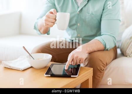 close up of man with tablet pc having breakfast Stock Photo