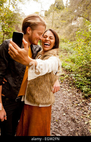 Woman and man taking a selfie in the woods. Stock Photo