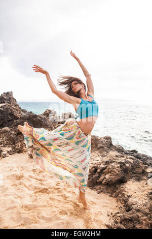 Woman dancing and jumping on beach. Stock Photo