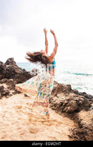 Woman dancing and jumping on beach. Stock Photo