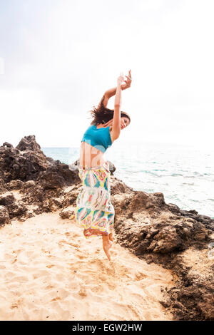 Woman dancing and jumping on beach. Stock Photo