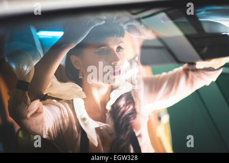 Woman fixing her hair in the car. Stock Photo