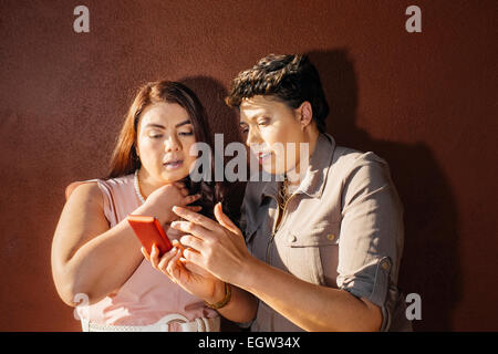 Two friends looking at cell phone. Stock Photo