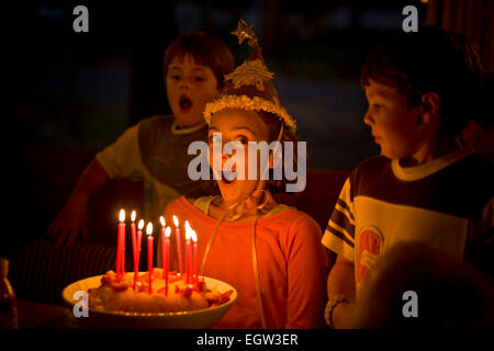 Girl about to blow out candles on a birthday cake.