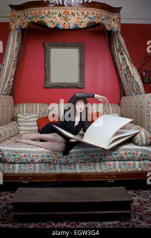 Woman looking through large scrapbook. Stock Photo