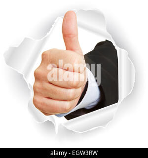 Hand breaking through paper and holding thumbs up as concept for business success Stock Photo