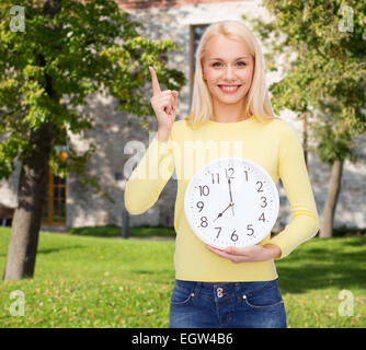 student with wall clock and finger up Stock Photo