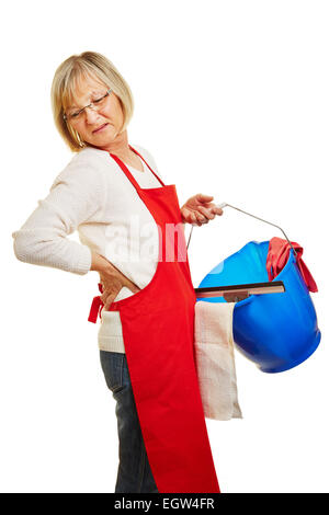 Cleaning lady with chronic back pain carrying cleaning supplies Stock Photo