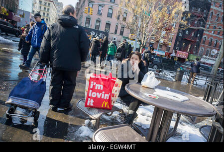 A woman eats her McDonald's lunch in a park in Chinatown in New York on Sunday, February 22, 2015.  (© Richard B. Levine) Stock Photo