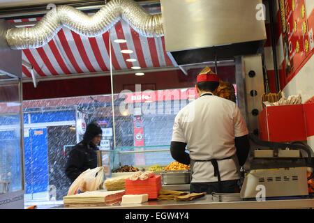 The chef slicing the doner in a doner restaurant in Istanbul, Turkey, while it's snowing outside. Stock Photo