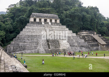 visitors wander around base of stepped pyramid structure Temple of the Inscriptions seen from steps of Palacio Palace Palenque Stock Photo