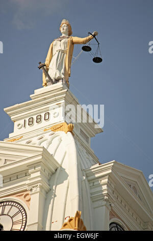 Statue of Lady Justice on top of a courthouse building on a sunny day Stock Photo