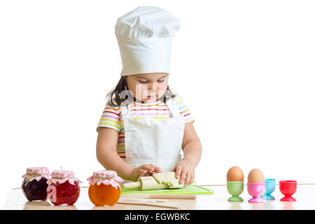 little baker kid girl in chef hat at kitchen Stock Photo