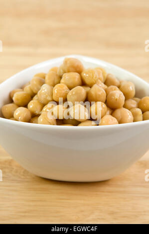 Chick peas in bowl on wooden table Stock Photo