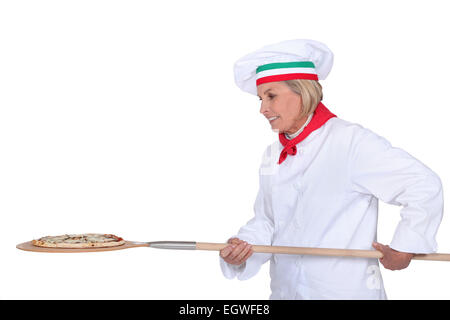 Italian chef putting a pizza in the oven Stock Photo