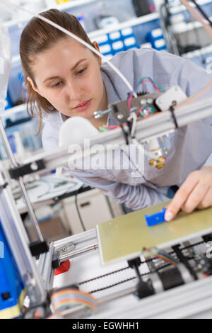 girl student makes the item on the 3D printer Stock Photo