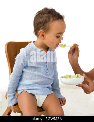 Little 18 month African toddler boy refusing to eat his vegetables Stock Photo